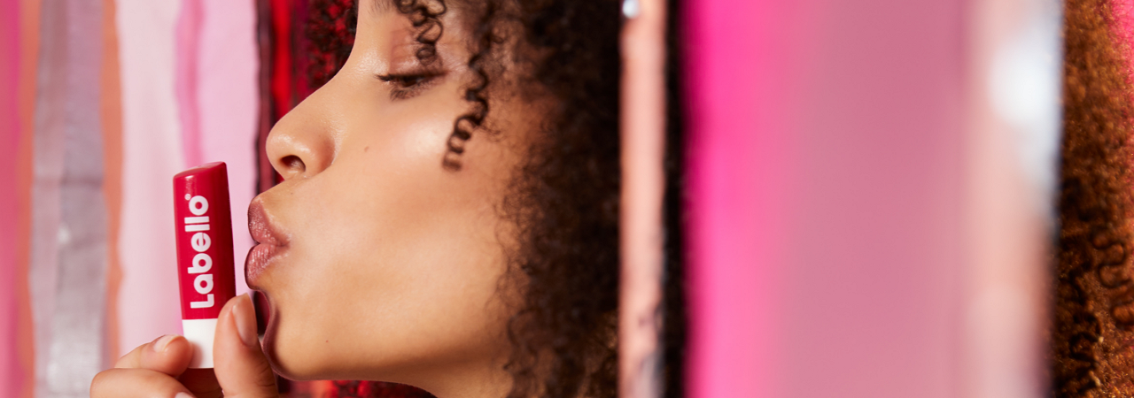 Verschiedene Labello Lippenpflegestifte arrangiert mit Blüten