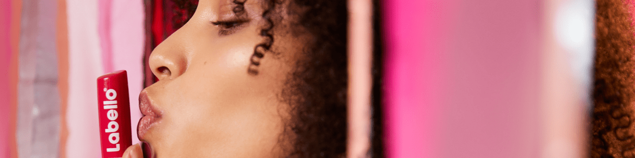 Verschiedene Labello Lippenpflegestifte arrangiert mit Blüten